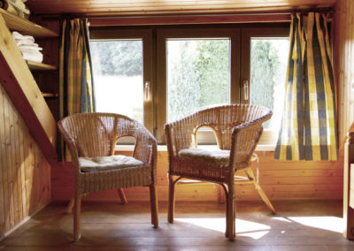 Gemütliche Sitzecke mit zwei Korbsesseln vor dem Fenster im Obergeschoss von Ferienhaus Meyer im Westerwald.