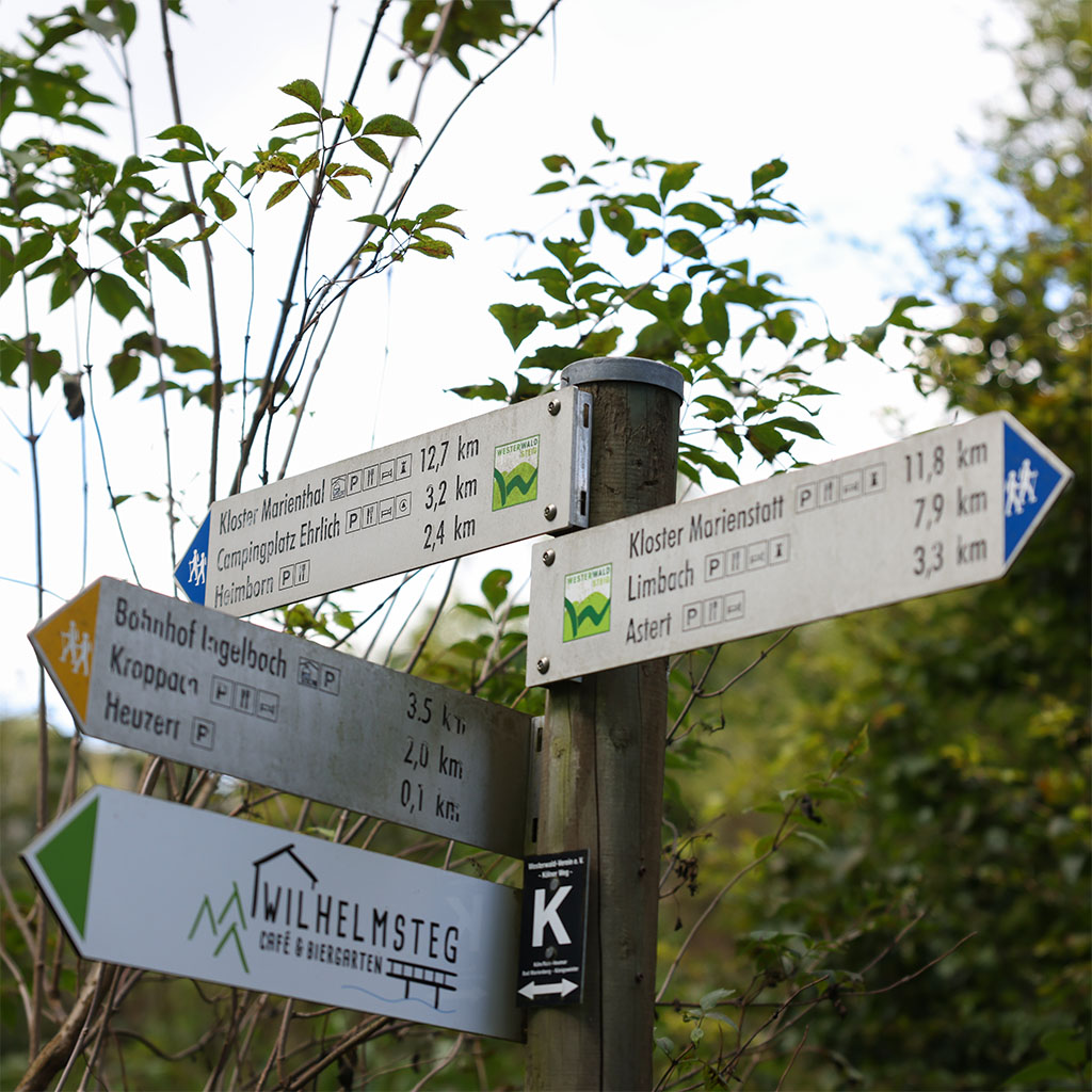 Wanderwegweiser im Westerwald nahe Ferienhaus Meyer mit Zielen wie Kloster Marienstatt und dem Wilhelmsteg