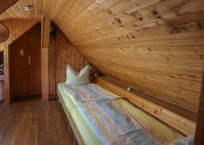 Gemütliches Schlafzimmer im Obergeschoss von Ferienhaus Meyer mit viel Naturholz und ländlichem Charme